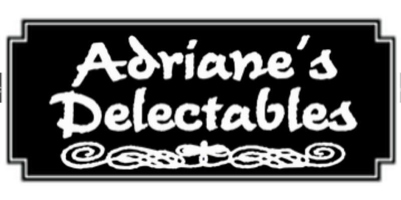 A black rectangular sign with a white border displays the words "Adriane's Delectables" in a stylized white font above a decorative white flourish.