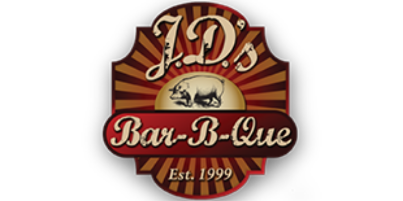 Logo for J.D.'s Bar-B-Que featuring a pig illustration, sunburst background, and text "Est. 1999.